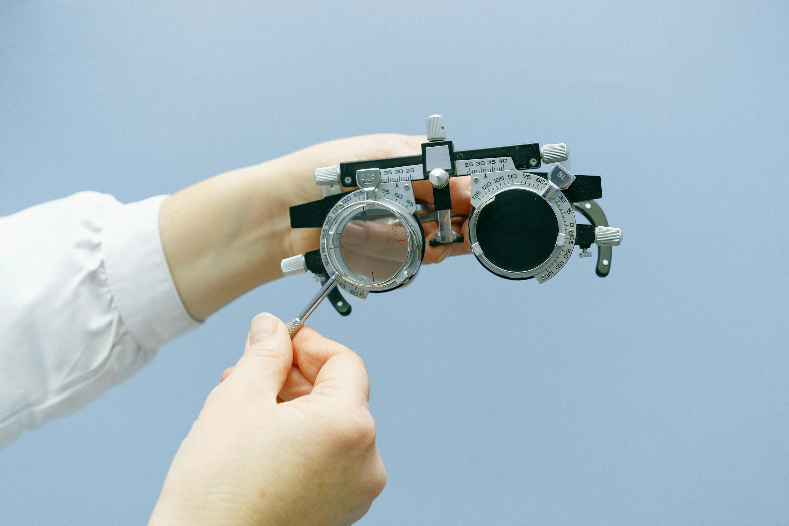 Crop unrecognizable doctor with vision test device